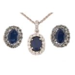 A sapphire and diamond halo earrings and necklace en suite; The earrings each comprises an oval