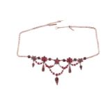 A garnet and red paste garland necklace in gilt metal, with florets, five-pointed stars and teardrop