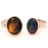 Two black opal rings; First consists of an oval Ethiopian opal cabochon, displaying play-of-colour