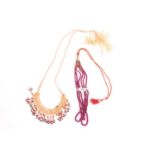 An Indian fringe necklace and a three-strand ruby bead necklace; the fringe necklace comprises