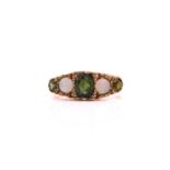 A tourmaline and opal dress ring, comprises a green oval-shaped mixed-cut tourmaline at the
