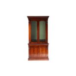 A Victorian figured mahogany collectors cabinet bookcase. The upper section with a pair of shaped
