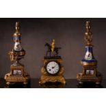 A small french Napoleon III patinated bronze and ormolu mantle clock with a surmount in the form