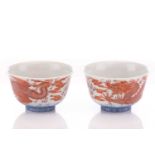 A pair of Chinese porcelain bowls, painted in iron red, one with a dragon the other with a