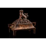 A Chinese bronze censer, of rectangular form, the pierced cover surmounted by a temple lion, the