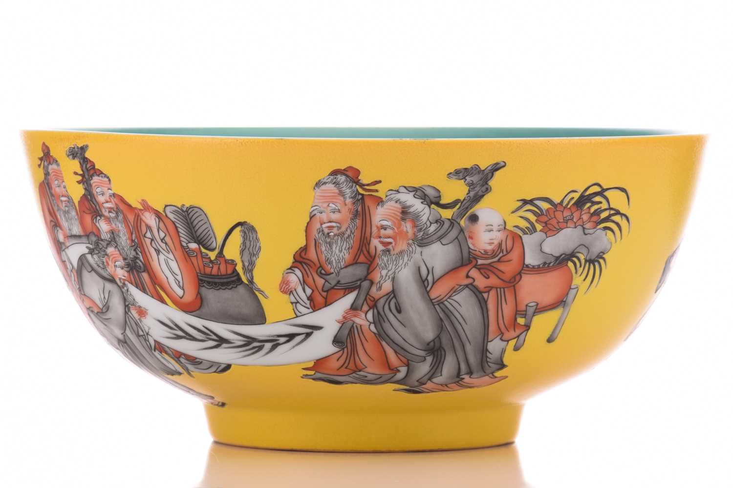 A Chinese porcelain bowl, painted with scholars reading scroll with boy attendants, on a yellow