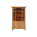 An architectural stripped pine open cupboard bookcase with lattice glazed flanks above a pair of
