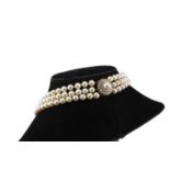 A three-strand pearl necklace with 18ct gold and diamond clasp, comprises three rows of round