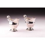 A pair of George II silver sauce boats, with gadrooned flared oval foot and rim, acanthus leaf