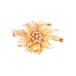 A floral brooch, depicting a flower head with textured spouting petals, stamens emanating from the