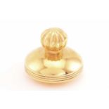 A saucer-shaped pill box in 18ct yellow gold, a mirror finished half dome with grooves on the