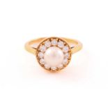 A pearl and diamond entourage ring in 18ct gold, featuring an 8.0 mm round pearl, cream-coloured