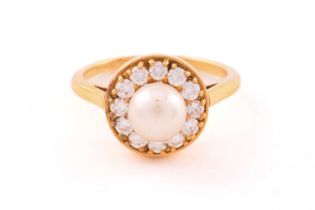 A pearl and diamond entourage ring in 18ct gold, featuring an 8.0 mm round pearl, cream-coloured