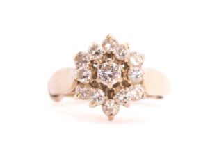 A three-tier diamond cluster ring, consisting of thirteen round brilliant-cut diamonds, claw set