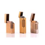 Three gold plated cigarette lighters; Swiss-made Dunhill lighter with cross-hatched patterns;