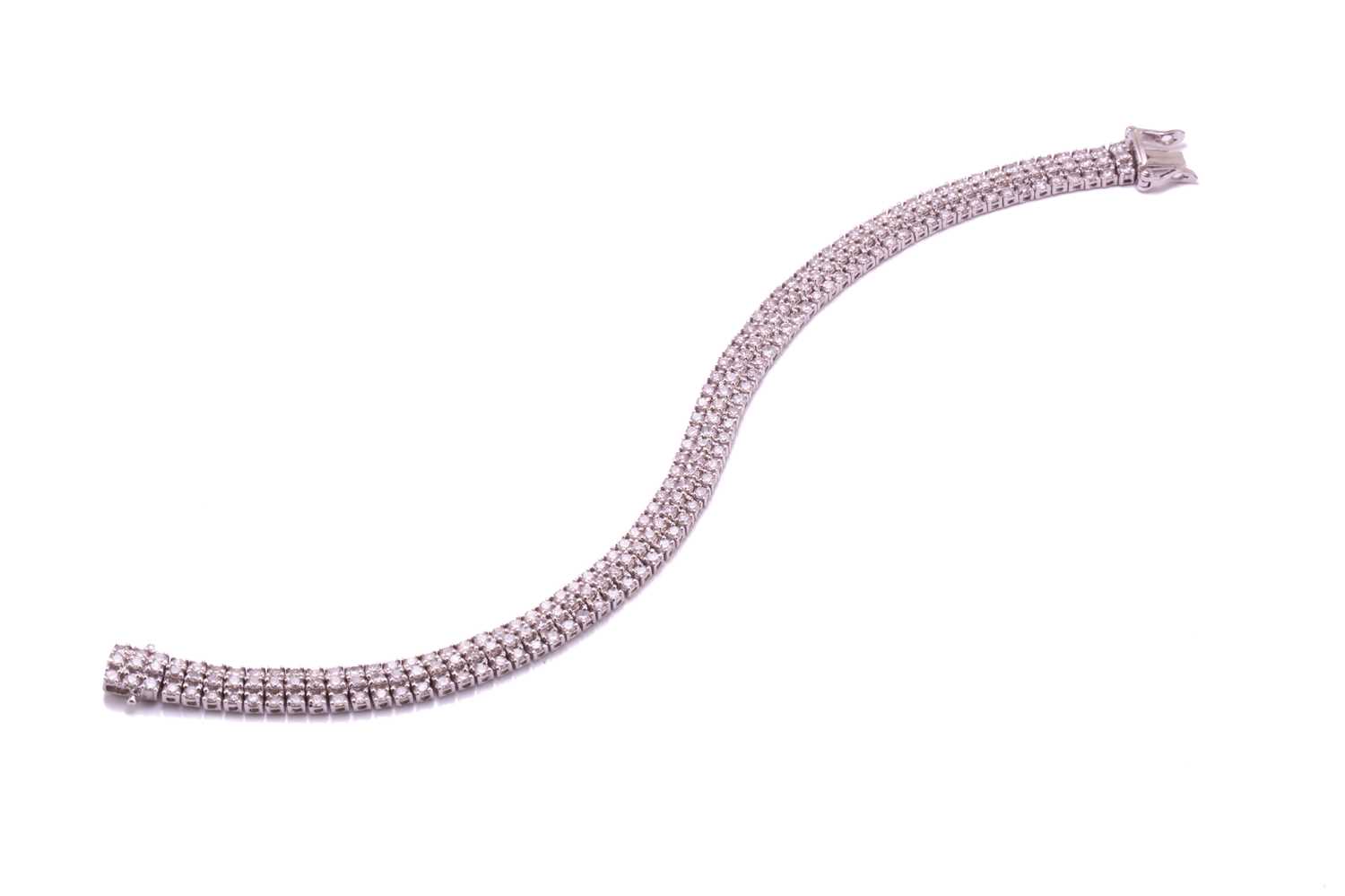 A three-row diamond tennis bracelet, featuring arrays of brilliant diamond with an estimated total