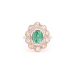 A synthetic emerald and diamond entourage ring, centrally set with an oval synthetic emerald of 7.