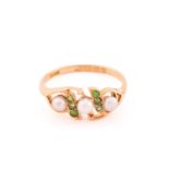 A pearl and demantoid garnet dress ring in 18ct gold, comprises three off round pearls where the one