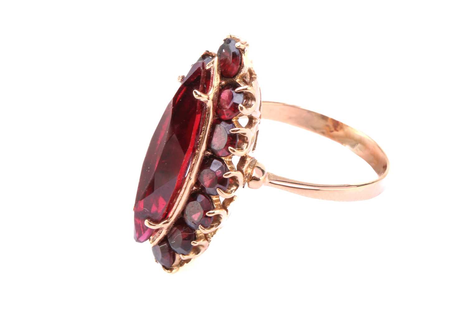 A synthetic ruby and garnet dress ring, comprises a marquise-shaped synthetic ruby claw-set on a