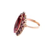 A synthetic ruby and garnet dress ring, comprises a marquise-shaped synthetic ruby claw-set on a