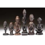 A Baule figure of a seated bearded man, Ivory Coast, with linear carved sculpted coiffure, the