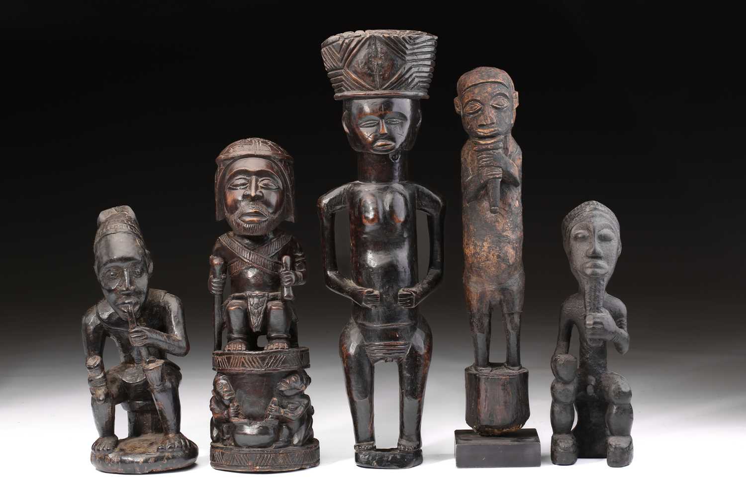 An Ibibio standing figure, Nigeria, a geometric carved bundle upon the head, the hands resting on