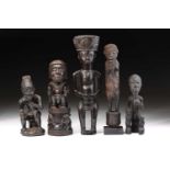 An Ibibio standing figure, Nigeria, a geometric carved bundle upon the head, the hands resting on