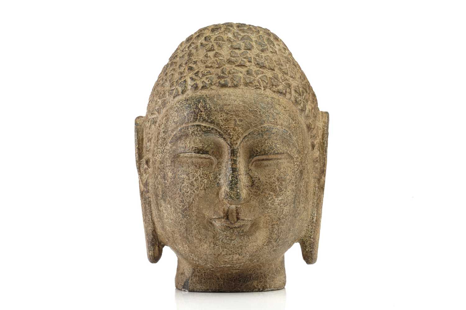 A Chinese-carved stone head of the Gautama Buddha with "snail shell" curls elongated ear lobes and