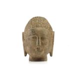 A Chinese-carved stone head of the Gautama Buddha with "snail shell" curls elongated ear lobes and