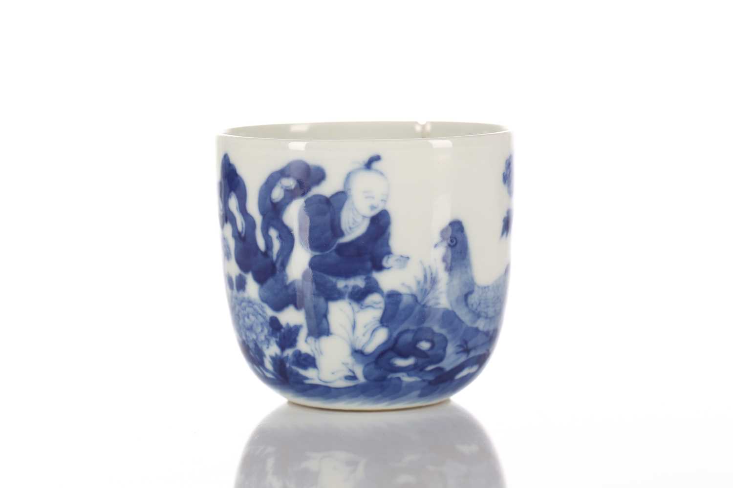 A Chinese blue & white chicken cup, Qing, painted with a boy and chicken between rocks and