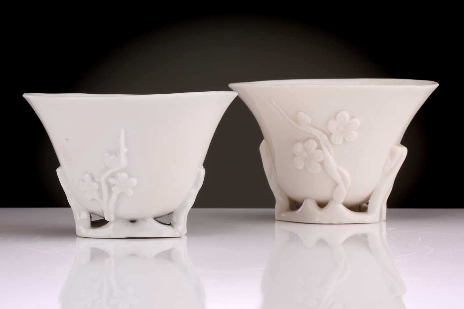 Two Chinese Dehua blanc de chine libation cups, Qing dynasty, 18th century, each with applied