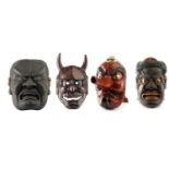 A collection of four Japanese carved wood oversized decorative Noh Theatre wall masks including