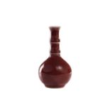 A Chinese small sang de boeuf bottle vase, with bamboo-effect neck, 11.8 cm high.