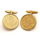 A pair of coin cufflinks, each features a Saudi Arabia one Guinea coin, one of the coins has '