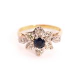 A sapphire and diamond flower head ring in 18ct gold, composed of a central faceted sapphire