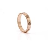 Cartier 'Love' ring. The polished 18 carat gold band decorated with screwhead motifs, signed
