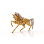 Mappin & Webb - An 18ct gold horse brooch set with diamonds, in the form of a galloping horse,