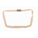 A two-row graduated pearl necklace with diamond clasp, comprises graduated round pearls in cream
