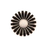 Georg Jensen - A black enamelled daisy brooch in silver, fitted with hinged pin stem and roll-over