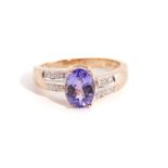 A tanzanite and diamond dress ring in 9ct gold, consisting of an oval faceted tanzanite of