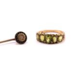 A five-stone peridot half hoop ring and an Etruscan revival diamond stick pin; the peridot ring