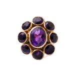 An amethyst cluster ring in 9ct yellow gold, with an oval faceted amethyst of 9.8 x 7.9 mm in the