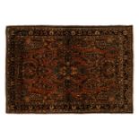 An old sarouk rug with a central medallion and floral sprays on a salmon pink ground. within