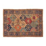 An old probably Kerman rug with an all-over mandorla-shaped tile ground filled with flower heads and
