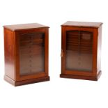 A pair of early 20th-century mahogany collectors cabinets each with an arched glazed panel door
