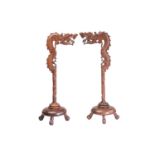 A close pair of Chinese carved wood lantern stands in the form of dragons with turned dome bases and