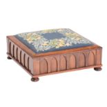 A Victorian figured rosewood square footstool with gothic arched frieze and drop-in needlework