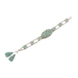 A carved jade and pearl bracelet, featuring an elongated oval jadeite plaque in a greyish-green