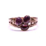 A Ruby and Garnet floral ring, formed from two Garnets claw set with a Ruby into a petal form on a