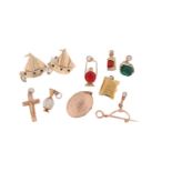 A collection of two brooches, pendants and charms. Consisting of two stone set sailing boat brooches